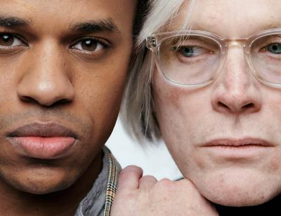 Close up of a black man and a white man wearing glasses, the white man has his hand on the black man's shoulder