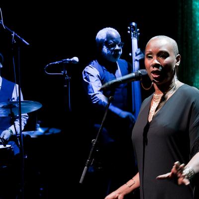 Josette Bushell-Mingo in front of two band members. Photo by Simon Annand
